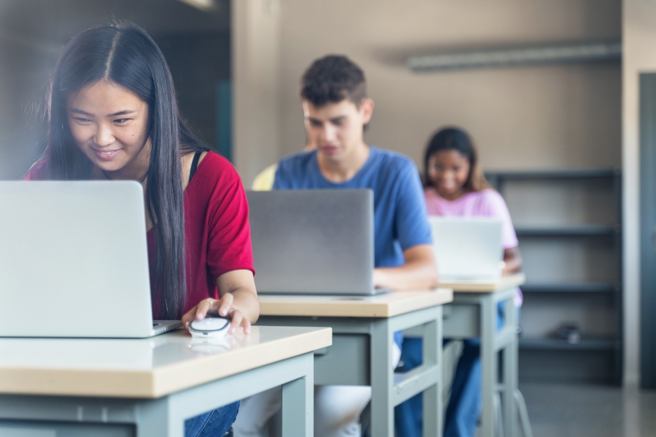 Diverse multi ethnic teenager college students studying with laptops at High School classroom