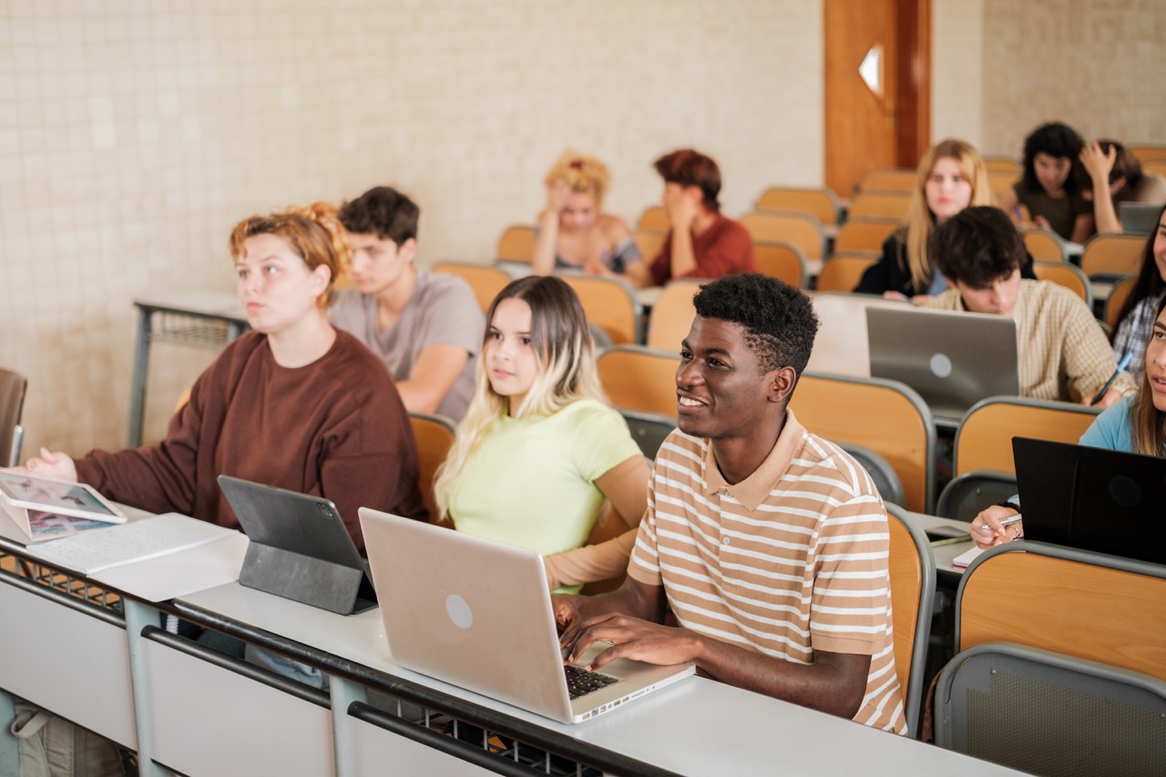 Young boys in university class with new technologies in the front row of the classroom